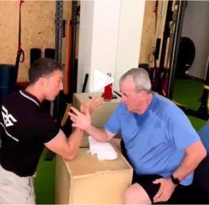 entrenador resiste el brazo a cliente en recuperación
